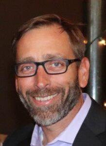 smiling man wearing glasses and with a short beard
